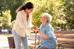 © Pixel-Shot - stock.adobe.com Alte Dame auf Bank und Pflegerin