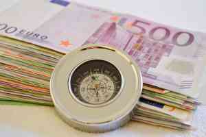 © Martina Wendt - stock.adobe.com Geldscheine mit eine Kompass davor